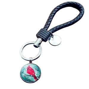 Close-up of handmade braided leather keychain with cardinal bird glass gem pendant