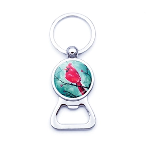 Macro view of silver bottle opener keychain with red cardinal glass dome artwork