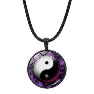 Macro shot of Yin Yang Tai Chi glass cabochon pendant with black rope necklace