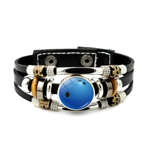 Detail of multi-layer leather bracelet featuring a blue bowling ball glass dome charm