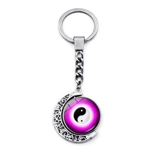 Detail of rotating Yin Yang butterfly pendant on crescent moon keychain with purple gradient