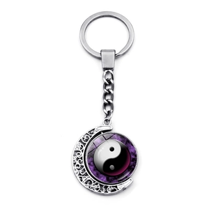 Macro detail of rotating yin yang charm with purple galaxy design and silver crescent frame