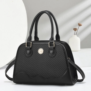 Detail view of black shell bag with herringbone knit texture and wavy leather bottom trim