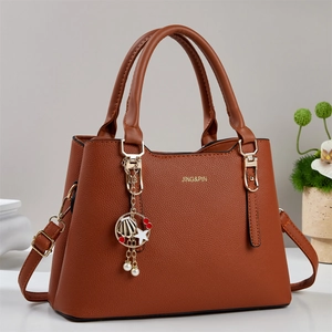 Brown litchi leather tote bag with gold hardware and sea-themed charm detail