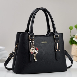 Borsa a mano nera in pelle martellata con logo dorato, ciondoli e tracolla