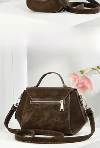 Detail view of the brown faux suede handbag showing back zipper pocket and gold hardware