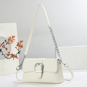 Detail of cream white shoulder bag with silver square buckle and metal chain strap