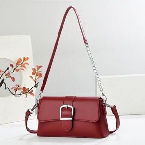 Deep red leather baguette shoulder bag with oversized silver buckle and chain strap