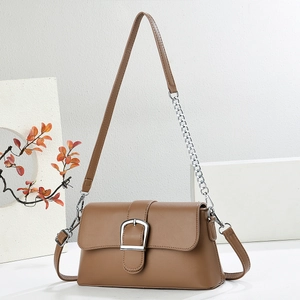 Modern brown leather baguette bag with silver hardware on a clean minimalist backdrop