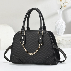 Close-up of black chevron pattern leather with gold chain detail and polished metal hardware