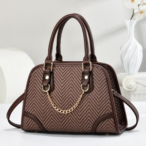 Elegant herringbone handbag with brown leather trim and golden chain strap detail