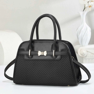 Elegant black handbag with herringbone fabric, leather trim and golden bow clasp