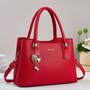 Sac à main rouge texture litchi avec breloques en métal et bandoulière réglable