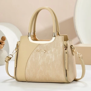 Detailed view of cream leather tote with vertical stripe texture and golden hardware