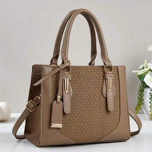 Detailed view of woven texture and smooth khaki leather on a stylish crossbody tote bag