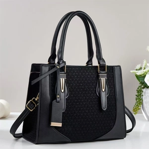 Chic black tote bag with woven texture, golden hardware, and detachable shoulder strap