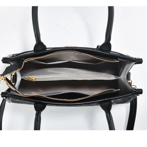 Vertical view showing multiple inner compartments and lining of the black tote bag