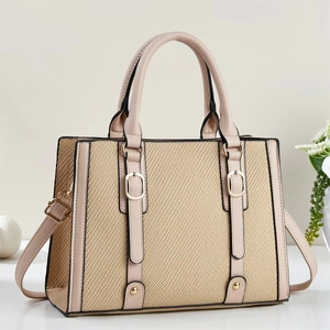 Fashionable beige woven straw and leather tote bag with elegant gold-tone hardware detail