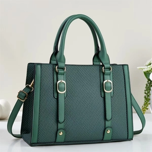 Deep green textured tote bag with smooth leather trim and elegant gold metal buckles