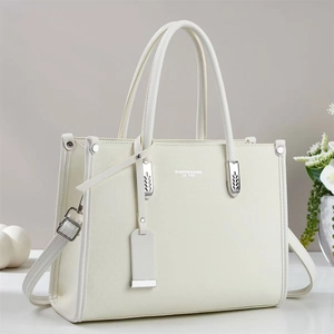 Detailed side view of cream leather tote bag with silver hardware and adjustable strap