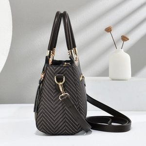 Détail d'un sac à main vintage à carreaux avec garniture en cuir brun et fermoirs dorés