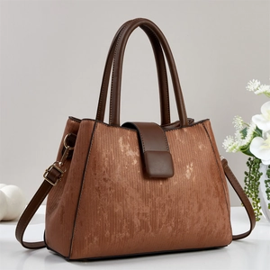 Brown vintage textured tote bag with top handles and shoulder strap on display