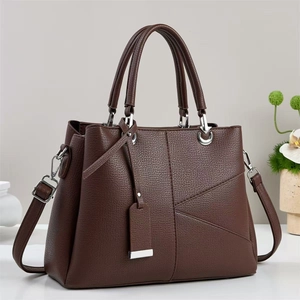 Close-up of dark coffee litchi grain leather handbag with geometric stitching details