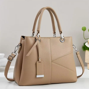 Detail of khaki leather handbag with geometric stitching and silver hardware accents