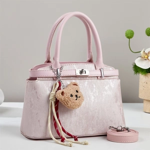 Pink glitter tote bag with metallic lock, teddy bear charm and adjustable shoulder strap