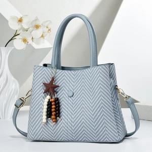 Elegante graublaue Handtasche mit Webmuster, Rundgriffen und Sternanhänger im Fokus