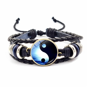 Détail du bracelet en cuir tressé avec symbole Yin Yang et perles argentées rétro