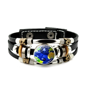 Dettaglio macro del ciondolo Yin Yang in vetro su bracciale in pelle multistrato