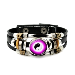 Dettaglio macro del bracciale multistrato in pelle con charm Yin Yang e intrecci
