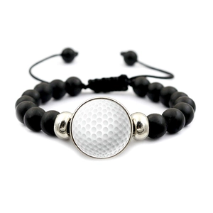 Macro-opname van matzwarte golf kralenarmband met golfbal bedeltje op een witte achtergrond