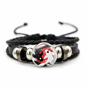 Nahaufnahme von Yin-Yang-Koi-Glascabochon auf schwarzem geflochtenem Lederarmband