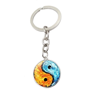 Detail of Yin Yang glass pendant keychain featuring fire and water element designs