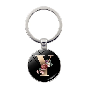 Close-up of a round alphabet Y keychain with elegant floral patterns on black background