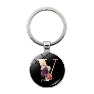 Close-up of letter V floral charm keychain with polished glass dome and gold metal ring