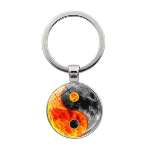 Vue détaillée du porte-clés yin yang argenté avec motif soleil et lune sur fond blanc