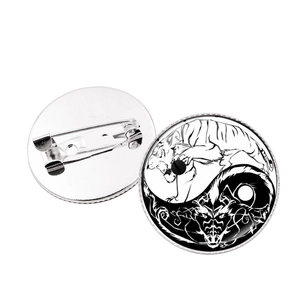 Yin Yang Dragon and Tiger brooch pins with silver alloy base on a white background