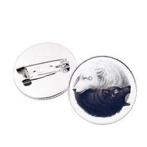 Detail of yin yang wolf badges showing front pattern and silver metal back safety pin