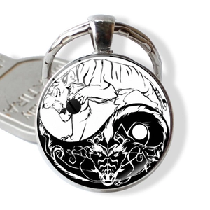 Detail van Yin Yang-sleutelhanger met draak en tijger patroon onder glazen koepel