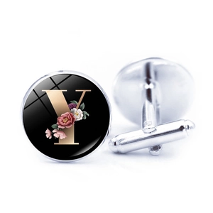 Macro shot of silver-plated cufflinks featuring a glass dome with letter Y and floral motifs