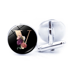 Detail of silver shirt cufflink with floral letter V design and T-shaped metal back