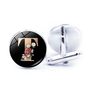 Close-up of circular shirt cufflink featuring gold letter T and floral design