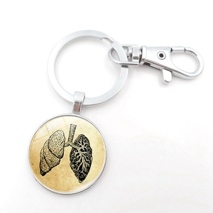 Detail of anatomical lung pendant with retro illustration under glass and silver keychain