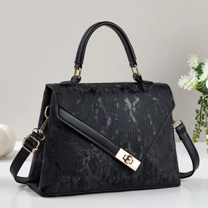 Sac à main noir minimaliste avec texture marbre, fermoir doré et bandoulière amovible