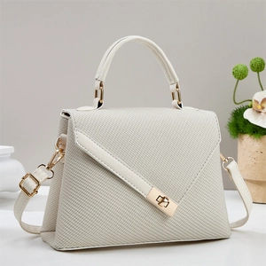 Detailed macro view of beige woven texture and gold metal turn-lock on luxury handbag