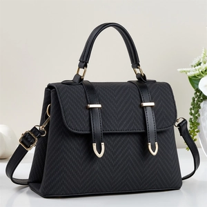 Detail of elegant black handbag with golden metal buckles and textured fabric finish