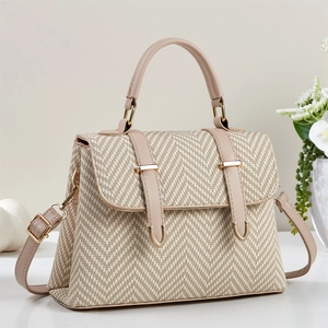 Detailed view of the woven herringbone texture and premium faux leather straps on the handbag